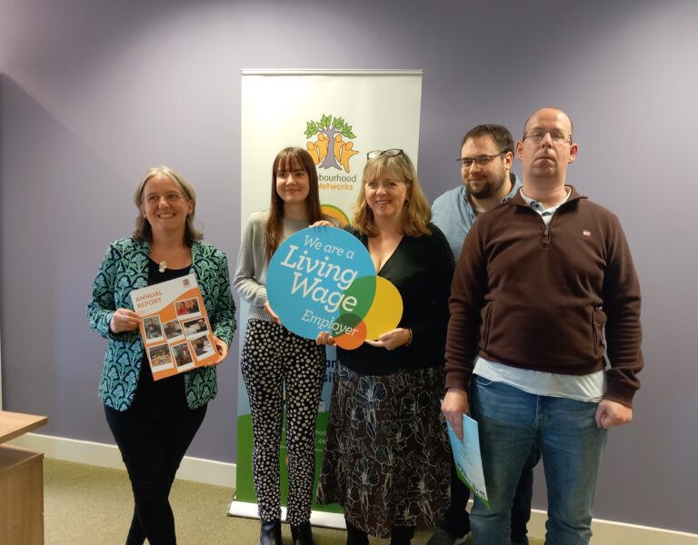 Ministerial Visit at Neighbourhood networks with 5 people holding the living wage sign