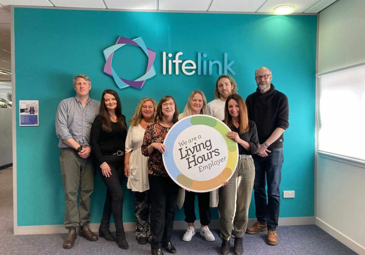 a group of people stand with a LH logo board