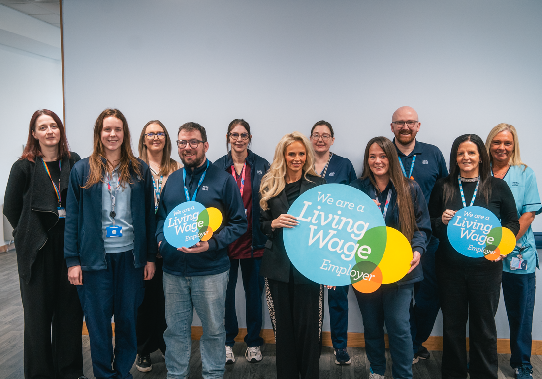 NHS 24 staff with Living Wage Scotland logoboards
